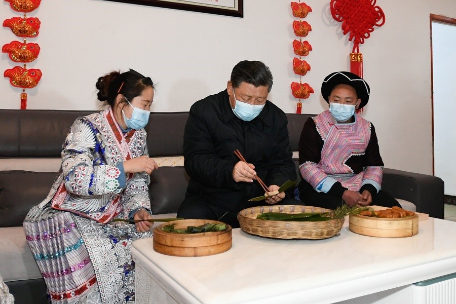 2021年2月3日下午，習(xí)近平在貴州畢節(jié)市黔西縣新仁苗族鄉(xiāng)化屋村苗族村民趙玉學(xué)家，同一家人邊聊家常邊制作當(dāng)?shù)貍鹘y(tǒng)節(jié)日食品黃粑。新華社記者 李學(xué)仁 攝