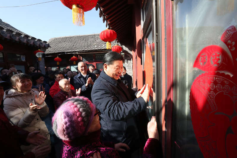 2019年2月1日上午，習(xí)近平在北京前門東區(qū)草廠四條胡同32號院，高興地拿起一幅“?！弊?，親自貼到門上，給這里的老街坊們拜年。新華社記者 鞠鵬 攝