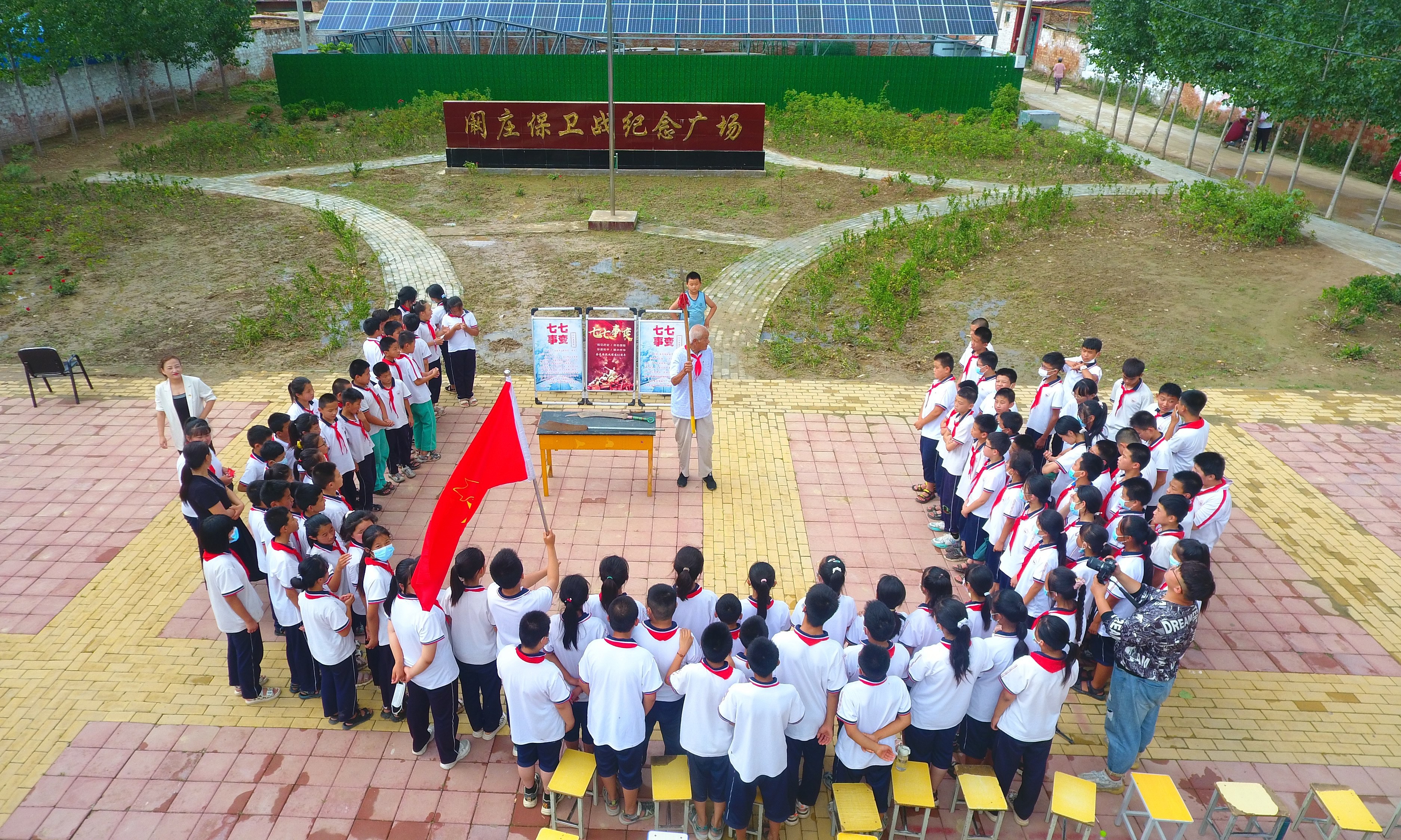 2022年7月6日，山東省聊城市，在茌平區(qū)菜屯鎮(zhèn)闞莊村的闞莊保衛(wèi)戰(zhàn)紀(jì)念廣場，闞莊保衛(wèi)戰(zhàn)親歷者王光木老人，為小學(xué)生們講述抗戰(zhàn)故事，展示大刀、長矛。